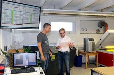 Prepress-Mitarbeiter Frank May (l.) und Geschäftsführer Holger Ostermann bei der Begutachtung der Druckplatten-Qualität