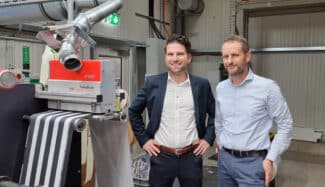 Christian Kröger, BST (links), und Mathias Baur, Projektingenieur bei Krämer Druck (rechts), vor einer Druckmaschine mit einem TubeScan-4k-Inspektionssystem